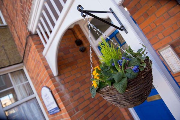 Front exterior of Abbeyfield House with hanging basket